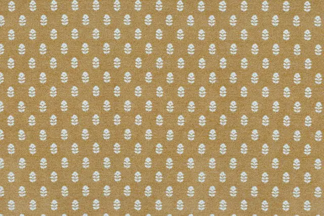 Ochre fabric with a repeating white floral motif pattern