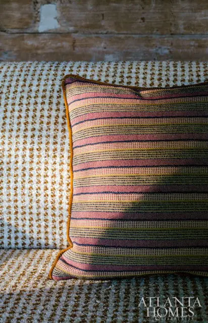 Striped throw pillow on textured sofa with wood plank wall