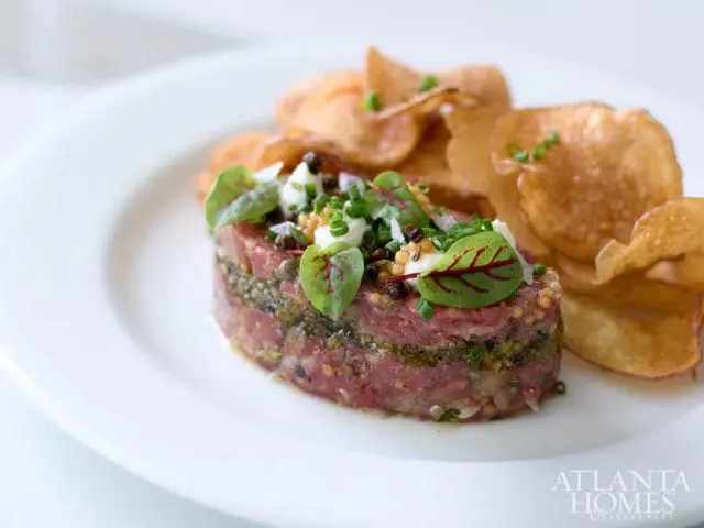 Beef tartare with capers, herbs, and potato chips. Atlanta Homes & Lifestyles logo.