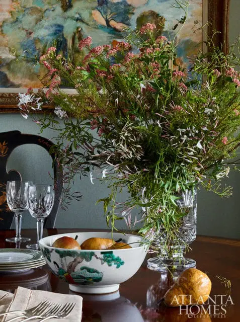 Bowl with pears and floral painting behind a bouquet of flowers