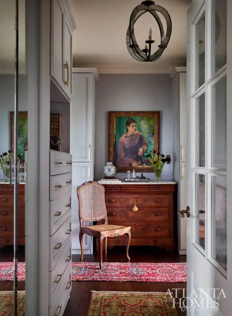 Gray built-in closet, antique dresser, cane chair, and oriental rugs