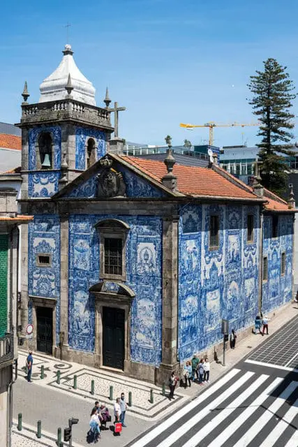 Church with blue and white tile facade, bell tower, and terracotta roof