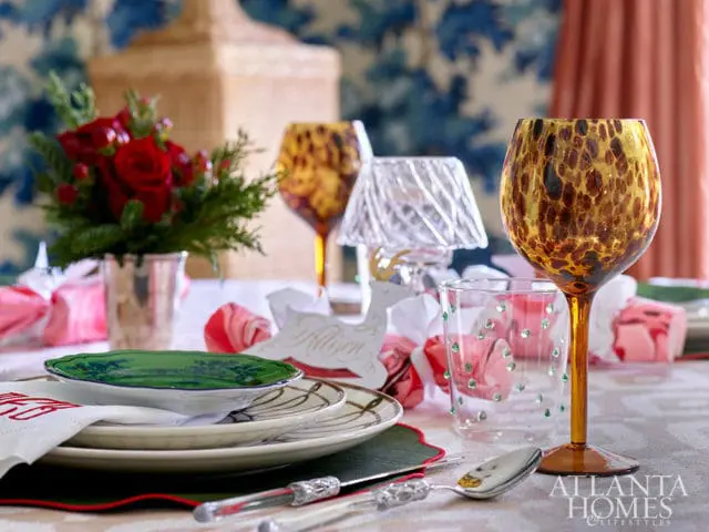 Table setting with floral plates, leopard print wine glass, and red roses