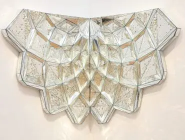 Geometric mirrored wall art with faceted surfaces and beveled edges