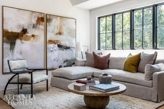 Living room with sectional sofa, abstract art, and wood coffee table.