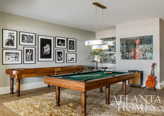 Game room with pool table, shuffleboard, and framed music photography.