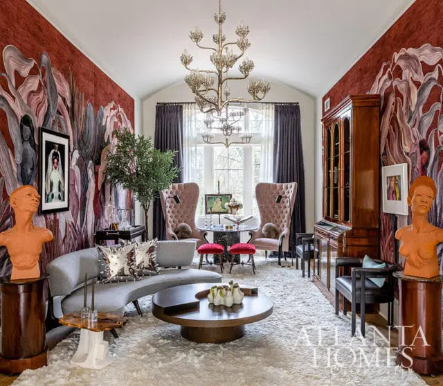 Living room with red floral wallpaper, gray curved sofa, and plush white rug.