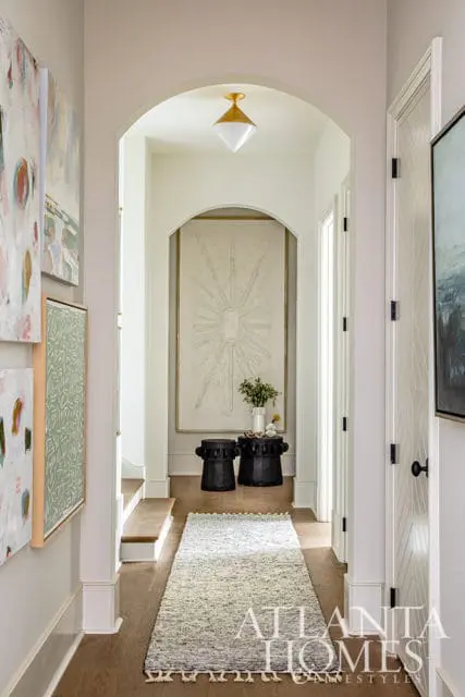 Hallway with abstract art, arched doorway, and geometric door