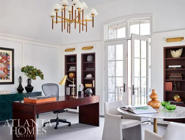 Office with dark wood desk, marble table, and built-in bookshelves.