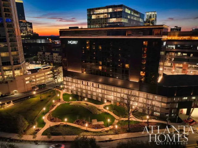 Nobu hotel at dusk with illuminated grounds and city skyline