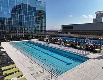 Rooftop pool with lounge chairs and modern glass building