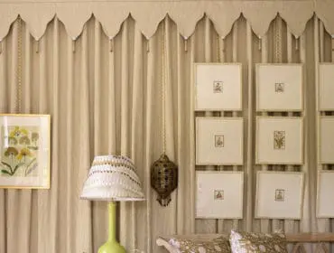 Living room with tan curtains, botanical prints, a lime green lamp, and patterned cushions on a