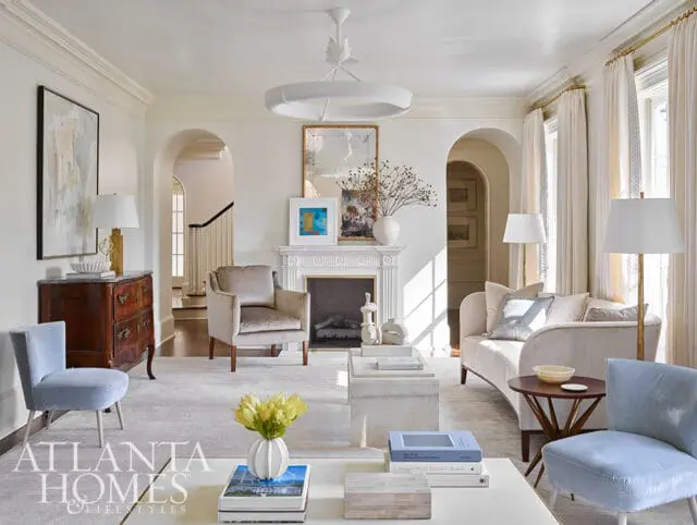 Living room with light blue chairs, cream sofa, fireplace, and Atlanta Homes & Lifestyles logo.