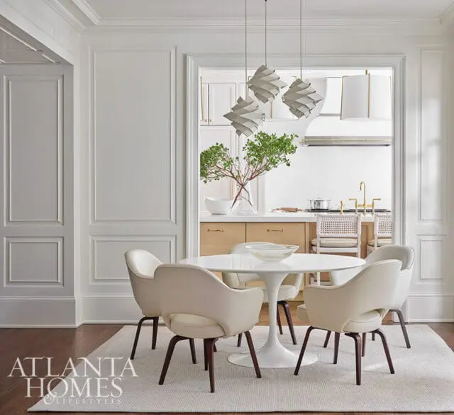 Dining area with white tulip table and chairs, view into kitchen