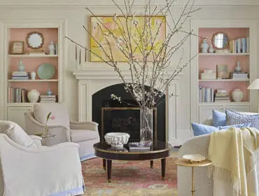 Living room with fireplace, built-in bookshelves, and upholstered chairs.