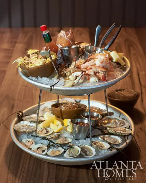Two-tiered seafood platter with oysters, clams, shrimp, crab, and Tabasco sauce
