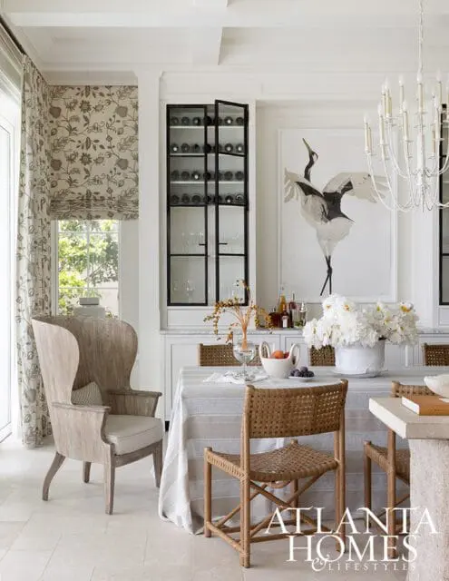 Dining room with striped tablecloth, woven chairs, and large crane artwork
