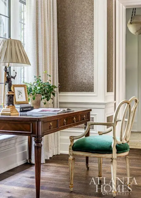 Dark wood desk with green velvet chair and Atlanta Homes & Lifestyles logo