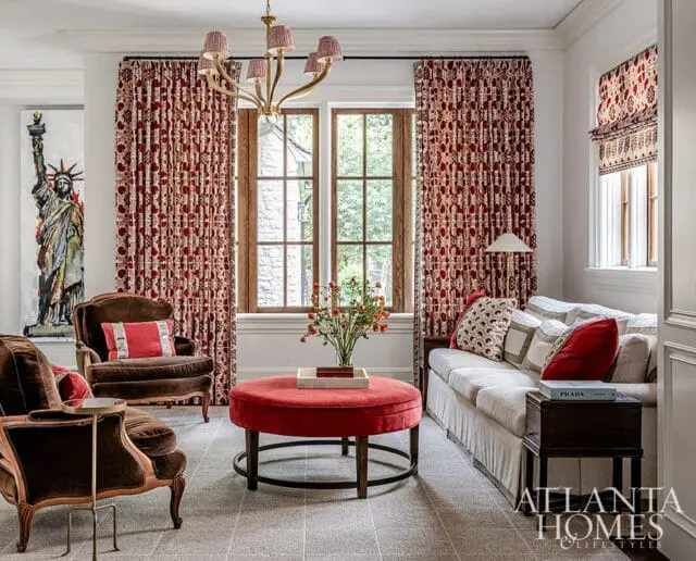 Living room with patterned red curtains, brown velvet chairs, and a white sofa.