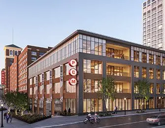 Modern building with glass facade and wood accents, featuring a PCM sign.