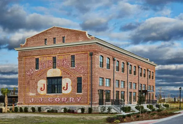Brick building with painted mural advertising "MATURED IRISH WHISKEY J.J. CORRY"