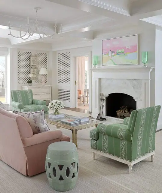 Living room with green striped armchairs, pink sofa, fireplace, and abstract art
