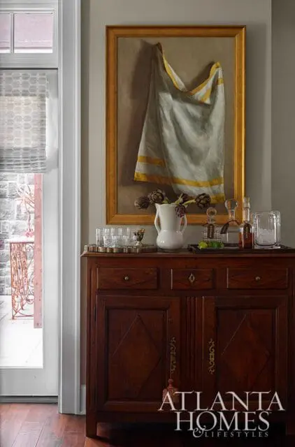 Dark wood cabinet with painting of draped cloth, artichokes, and barware.