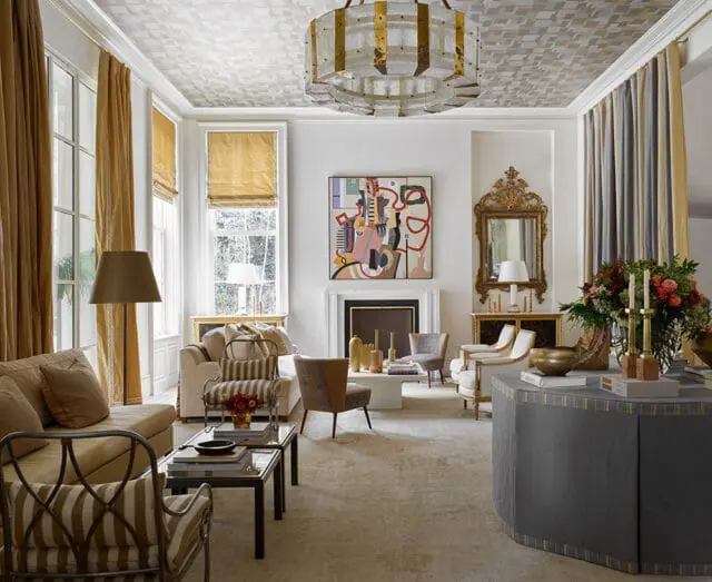 Living room with patterned ceiling, abstract art, fireplace, and gold accents