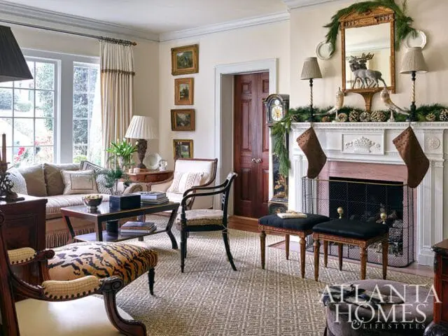 Living room with fireplace decorated for Christmas, featuring stockings, garland, and a moose