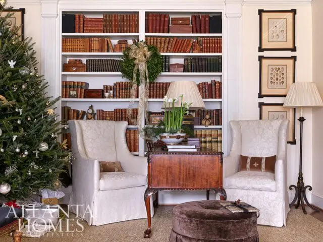 Living room with Christmas tree, built-in bookshelves, and two wingback chairs.