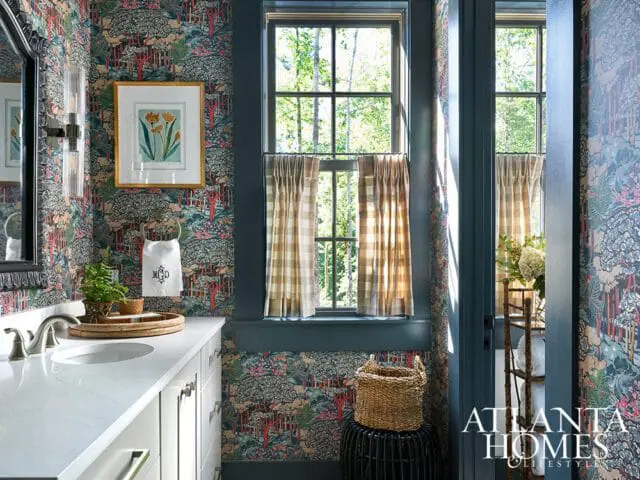 Bathroom with bold floral wallpaper, white vanity, and plaid curtains.