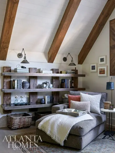 Living room with vaulted ceiling, exposed wood beams, built-in shelves, and chaise lounge.