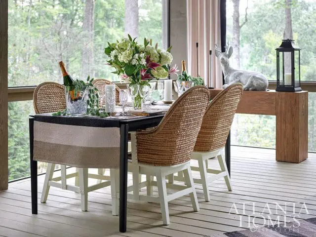 Dining table with wicker chairs, champagne bucket, floral arrangement, and deer statue