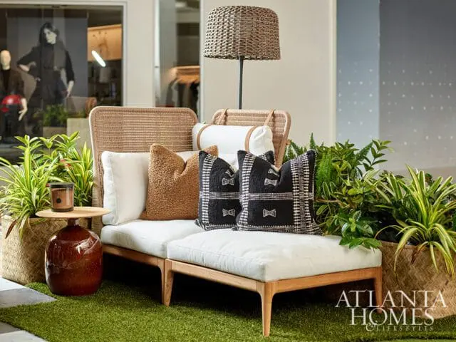 White outdoor sofa with black and white patterned pillows and a brown textured pillow.