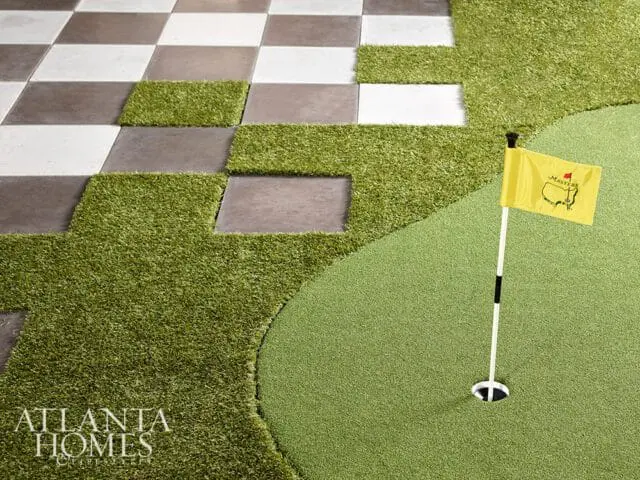 Yellow Masters flag on putting green next to checkered patio