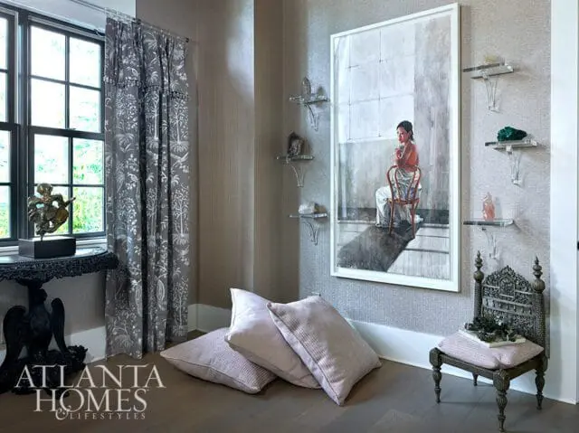 Living room with patterned curtains, artwork of a woman on a chair, and decorative pillows