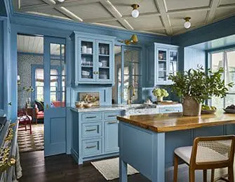 Blue kitchen with paneled ceiling, marble countertops, and wood island