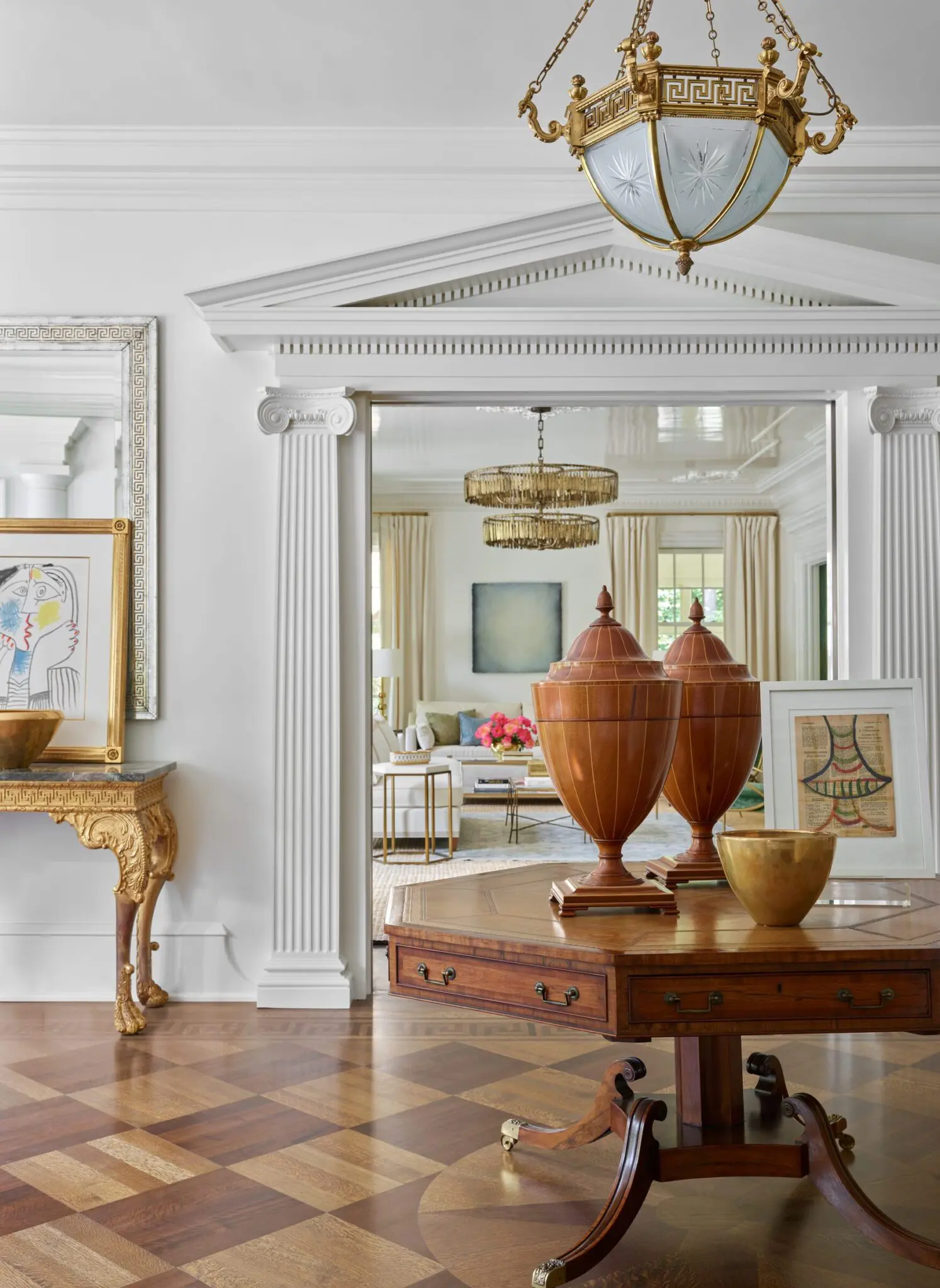 Entryway with parquet flooring, ornate console table, and doorway to living room.