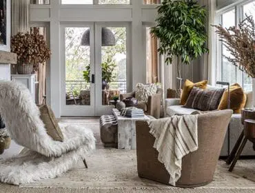 Living room with white shag chair, brown armchair, neutral sofa, and rustic wood accents.