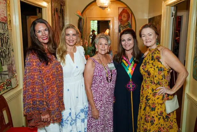 Five women at a garden party, indoors.