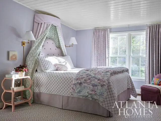 Bedroom with a canopy bed, lavender walls, floral bedding, and a pink side table. A logo for Atlanta Homes & Lifestyles is visible in the lower right corner.