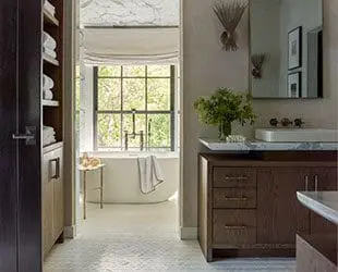 Bathroom with dark wood vanity, marble countertop, white sink, and freestanding tub