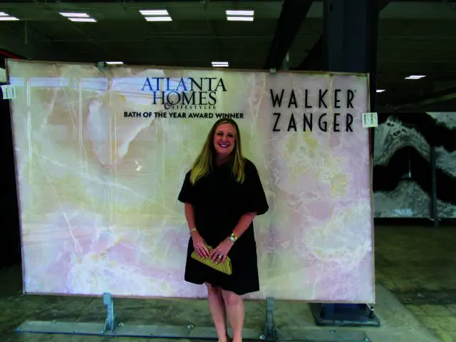 Woman in black dress standing in front of a large pink marble slab with Atlanta Homes & Lifestyles