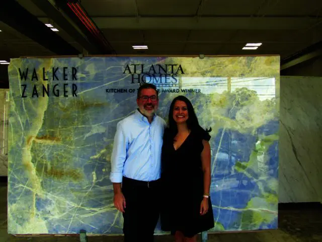 Man and woman in front of blue marble slab with Walker Zanger and Atlanta Homes logos