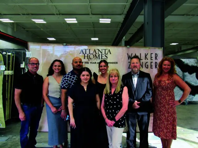 Group posing in front of Atlanta Homes & Lifestyles banner with Walker Zenger logo