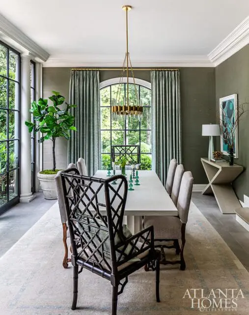 Dining room with green grasscloth walls, white table, and dark bamboo chairs.