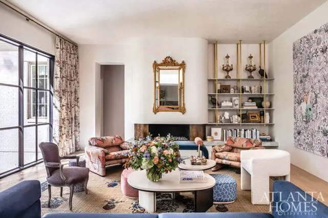 Living room with floral chairs, ornate mirror, built-in shelves, and Atlanta Homes & Lifestyles logo