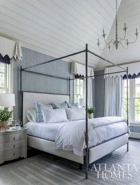 Bedroom with a four-poster bed, blue textured wallpaper, and white paneled ceiling.
