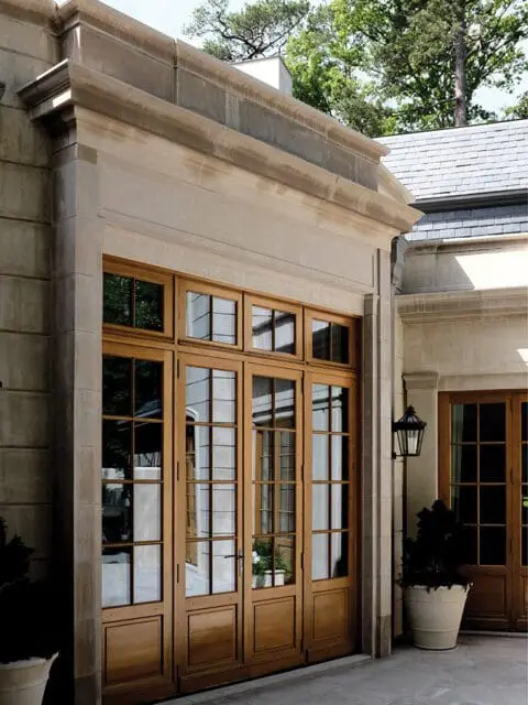 Stone building exterior with large wooden French doors and windows.