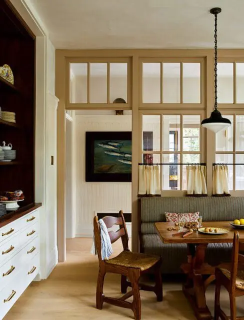 Dining area with built-in banquette, wooden table and chairs, and built-in cabinetry.